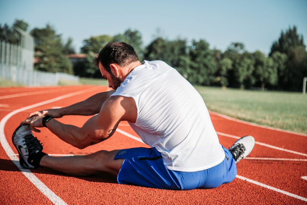 Man stretching on track sports medicine